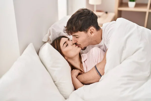 男と女カップルキスと巨大お互いにベッドの上に横たわっています ベッドルーム — ストック写真