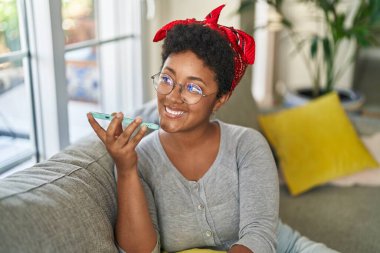 Afro-amerikan kadın akıllı telefonuyla konuşuyor.