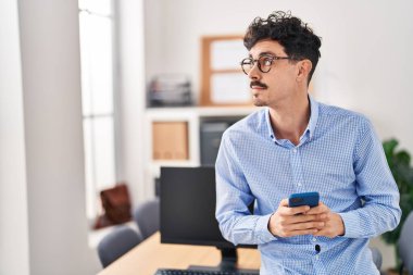 Ofiste akıllı telefon kullanan beyaz bir iş adamı.