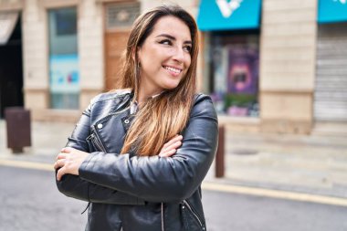 Sokakta kollarını kavuşturmuş genç, güzel İspanyol bir kadın.