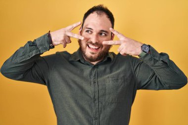 Ayrıca sarı arka planda sakallı İspanyol bir adam. Yüzünde parmaklarıyla barış sembolü yapıyor. Gülümsüyor, zafere gülümsüyor. 