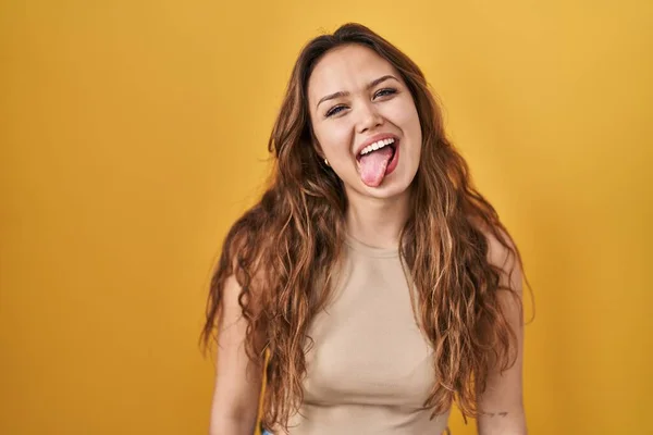 Mujer Hispana Joven Pie Sobre Fondo Amarillo Sacando Lengua Feliz —  Fotos de Stock