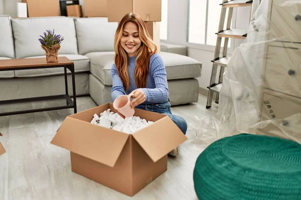 Young Caucasian Woman Smiling Confident Unpacking Cardboard Box New Home — ストック写真