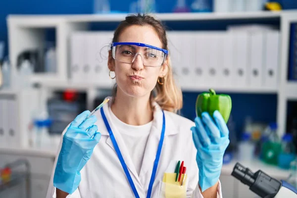 Mulher Hispânica Jovem Trabalhando Laboratório Cientista Com Legumes Soprando Bochechas — Fotografia de Stock