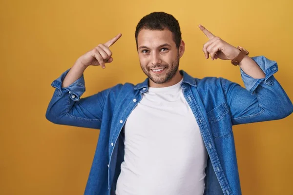 Hispanic Man Standing Yellow Background Smiling Pointing Head Both Hands — Φωτογραφία Αρχείου