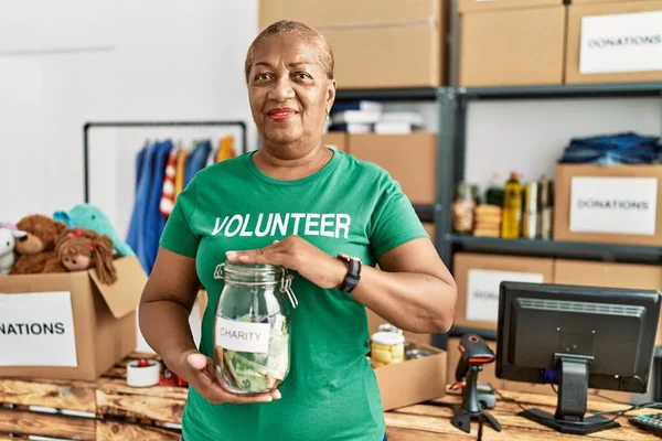 Mujer Afroamericana Mayor Con Uniforme Voluntario Sosteniendo Tarro Con Dinero —  Fotos de Stock