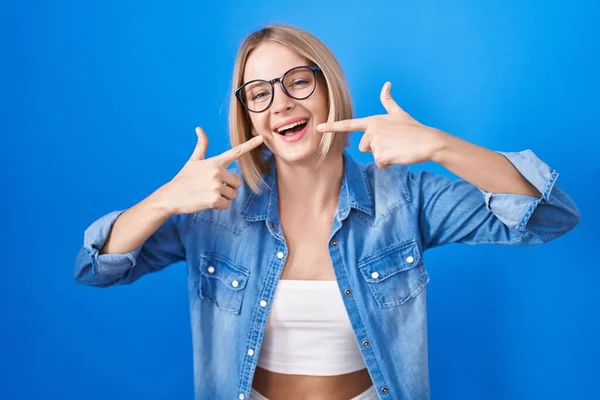 Jonge Blanke Vrouw Staat Blauwe Achtergrond Lachend Vrolijk Tonen Wijzen — Stockfoto
