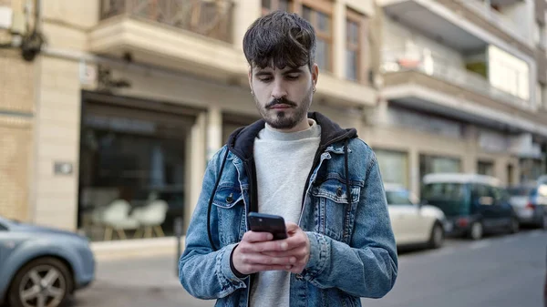 ストリートでスマートフォンを使う若いヒスパニック系の男 — ストック写真