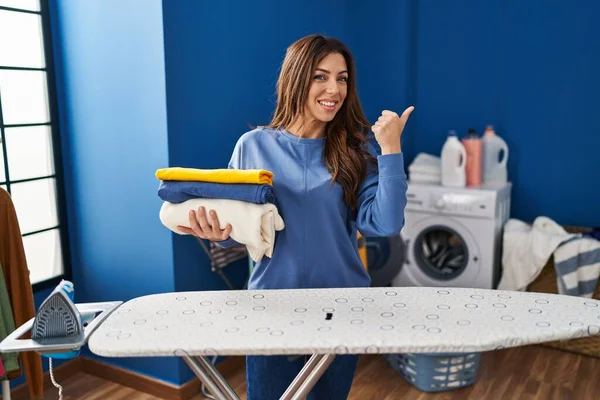 Jong Brunette Vrouw Holding Gevouwen Wasgoed Strijken Glimlachen Gelukkig Wijzend — Stockfoto
