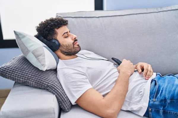 Mladý Arabský Muž Poslouchá Hudbu Spící Pohovce Doma — Stock fotografie