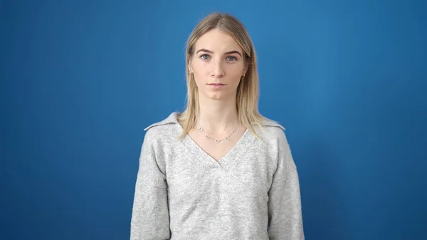 Ung Blond Kvinna Står Med Allvarliga Uttryck Över Isolerad Blå — Stockfoto