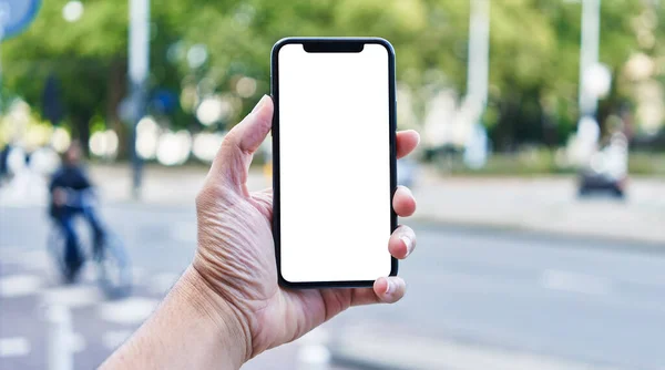 stock image Man holding smartphone showing white blank screen at street