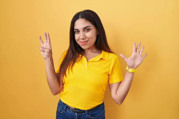 Sarı Arka Planda Duran Genç Arap Kadın Sekiz Numaralı Parmaklarıyla — Stok fotoğraf