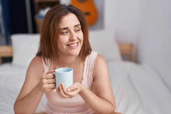 Młoda Kobieta Pije Kawę Siedząc Łóżku Sypialni — Zdjęcie stockowe