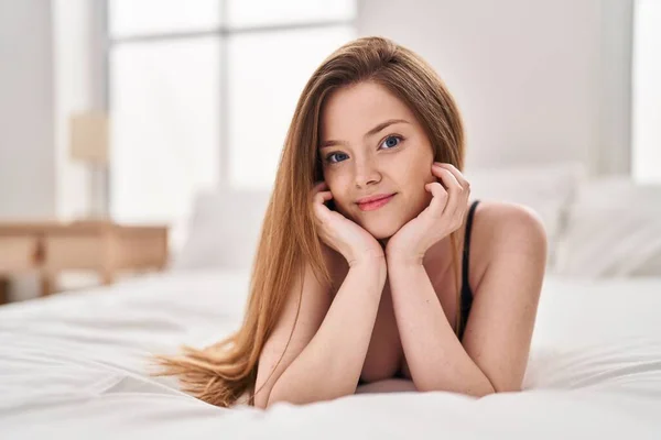Młoda Biała Kobieta Uśmiecha Się Pewnie Leżąc Łóżku Sypialni — Zdjęcie stockowe