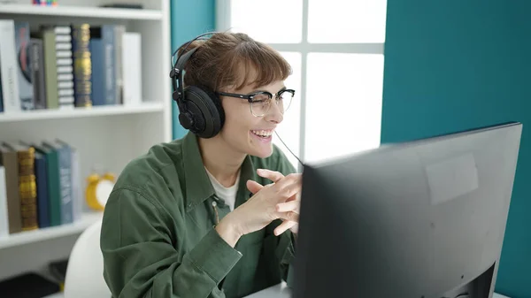 Kütüphanede Kulaklık Takan Beyaz Bir Kadın Bilgisayar Kullanıyor — Stok fotoğraf