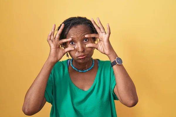 Αφρικανική Γυναίκα Dreadlocks Στέκεται Πάνω Από Κίτρινο Φόντο Προσπαθεί Ανοίξει — Φωτογραφία Αρχείου