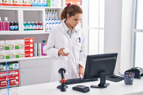 Young Woman Pharmacist Holding Pills Bottle Using Computer Pharmacy — 스톡 사진