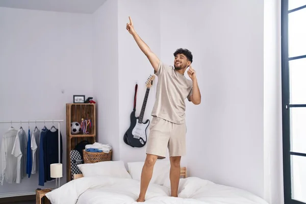 Ung Arabisk Man Ler Säker Stående Sängen Sovrummet — Stockfoto