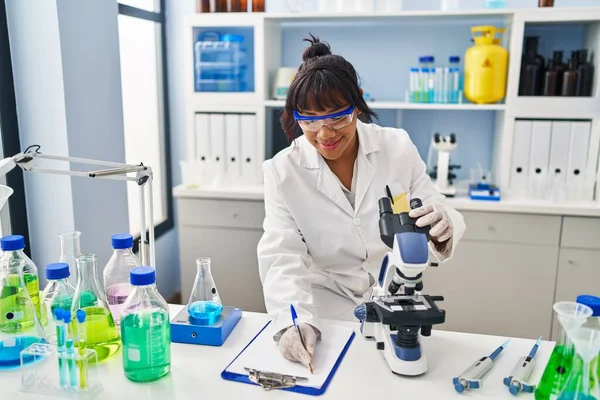 Young Beautiful Latin Woman Scientist Using Microscope Writing Report Laboratory — Stock fotografie
