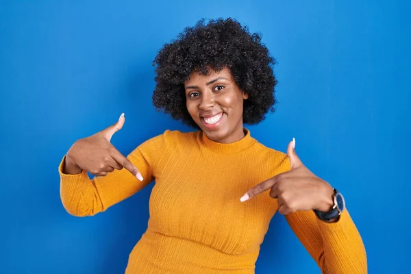 Zwarte Vrouw Met Krullend Haar Staan Blauwe Achtergrond Kijken Zelfverzekerd — Stockfoto