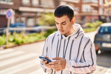 Young man using smartphone at street