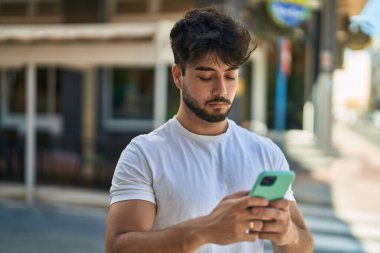 Sokakta akıllı telefon kullanan genç bir İspanyol.