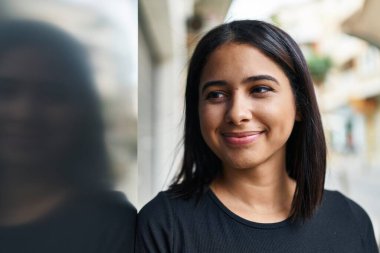 Sokakta kendine güvenen genç Latin kadın gülümsüyor