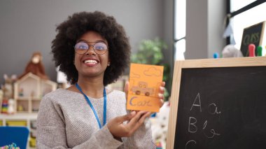 African american woman preschool teacher having vocabulary lesson at kindergarten