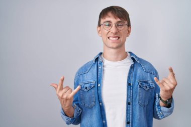 Beyaz, sarışın, gözlüklü, çılgın bir ifadeyle bağıran, elleri havada rock sembolü yapan bir adam. Müzik yıldızı. ağır müzik konsepti. 