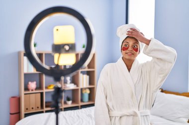 Koyu renk saçlı İspanyol bir kadın akıllı telefonuyla güzellik dersi kaydediyordu. Eli kolu bağlı, şaşırmış ve sinirli bir yüz ifadesi vardı. 