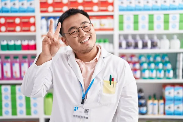 Čínský Mladík Pracující Lékárně Usmívá Dívá Kameru Ukazující Prsty Ukazující — Stock fotografie