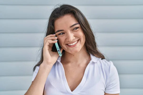 Mujer Hispana Joven Sonriendo Confiada Hablando Teléfono Inteligente Sobre Fondo — Foto de Stock