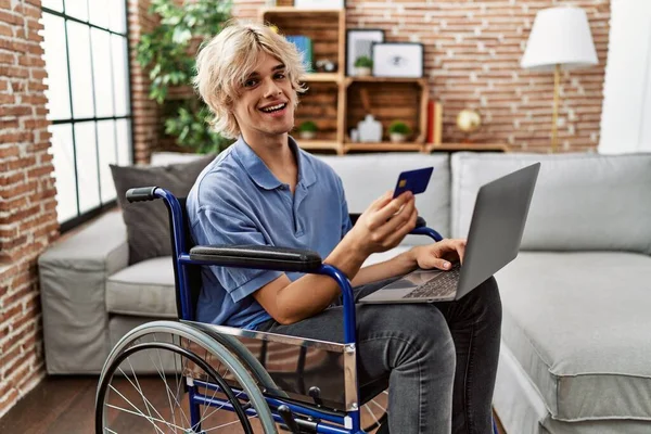 Jovem Loiro Usando Laptop Cartão Crédito Sentado Cadeira Rodas Casa — Fotografia de Stock