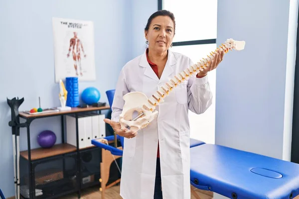 Medelålders Latinamerikanska Kvinna Med Anatomisk Modell Ryggraden Avslappnad Med Allvarliga — Stockfoto