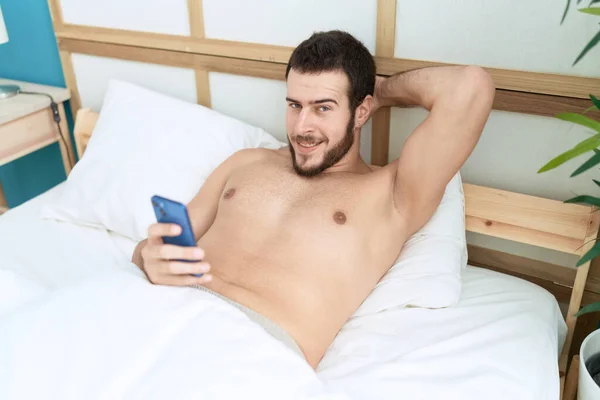 Νεαρός Ισπανός Που Χρησιμοποιεί Smartphone Ξαπλωμένος Στο Κρεβάτι Στην Κρεβατοκάμαρα — Φωτογραφία Αρχείου