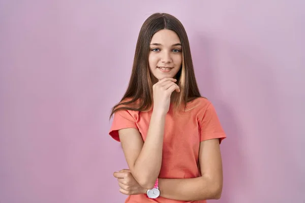 Chica Adolescente Pie Sobre Fondo Rosa Con Mano Barbilla Pensando —  Fotos de Stock