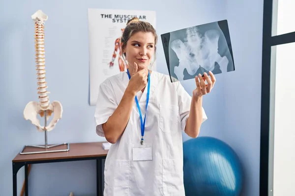 骨盤X線撮影の深刻な顔を保持若い女性は顎に手で質問について考えて 混乱のアイデアについて思慮深い — ストック写真