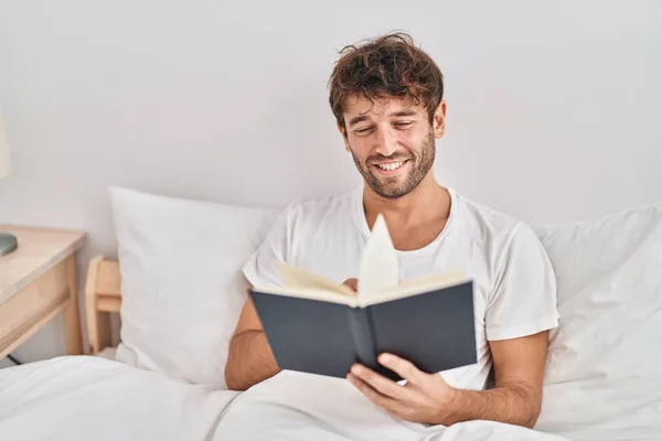 Молодой Человек Читает Книгу Сидя Кровати Спальне — стоковое фото
