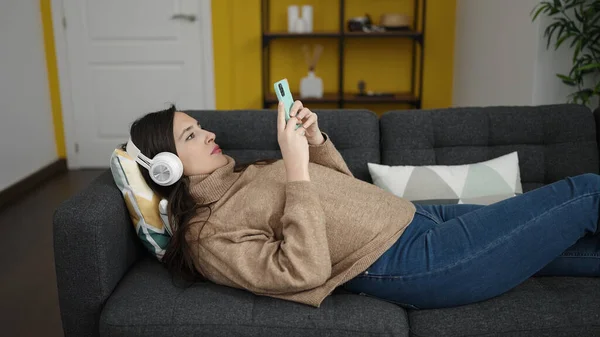 Mooie Spaanse Vrouw Luisteren Naar Muziek Met Smartphone Liggend Bank — Stockfoto