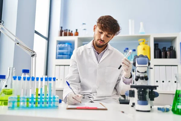 Young Arab Man Scientist Write Document Analysing Blood Test Tube — Stockfoto