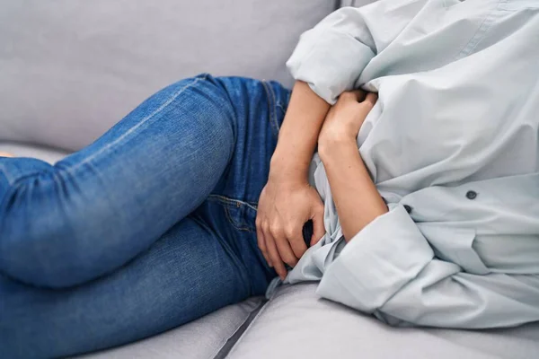 Young Woman Suffering Menstrual Pain Lying Sofa Home — Stockfoto