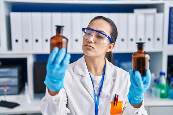 Young Hispanic Woman Scientist Holding Bottles Laboratory — Stock Photo, Image