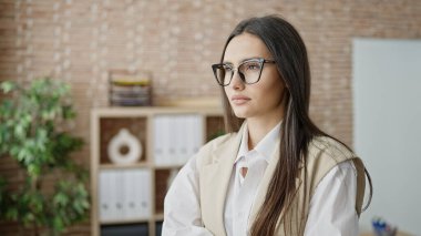 Young beautiful hispanic woman business worker standing with relaxed expression at office