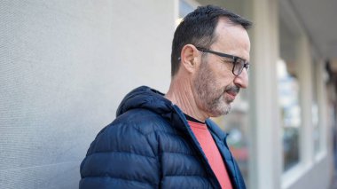 Çağrı merkezi kulaklığı takan orta yaşlı bir adam mutlu bir gülümseme ve el kaldırarak zaferi kutluyor. 