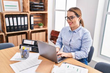 Young beautiful hispanic woman business worker using laptop working at office