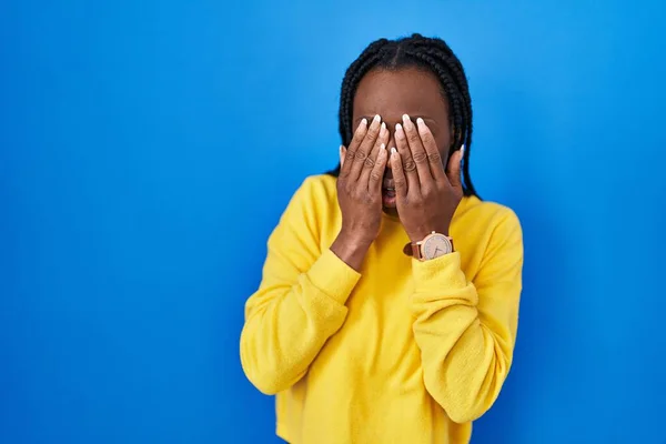 Mooie Zwarte Vrouw Staat Blauwe Achtergrond Wrijven Ogen Voor Vermoeidheid — Stockfoto