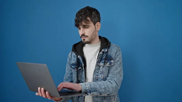 Zole Edilmiş Mavi Arka Planda Dizüstü Bilgisayar Kullanan Genç Bir — Stok fotoğraf