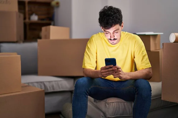 Young Caucasian Man Using Smartphone Sitting Sofa New Home — Stock fotografie