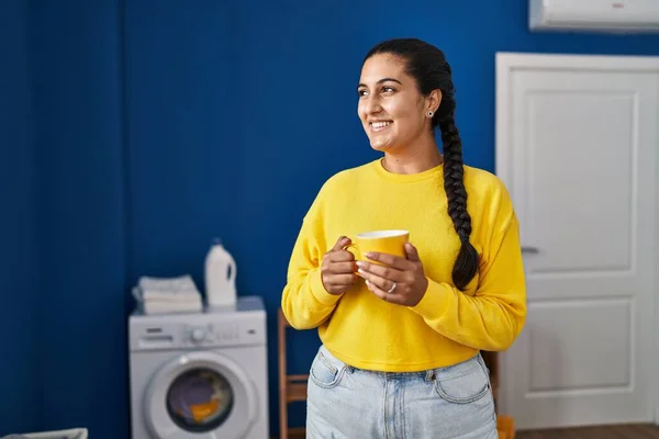 Young Hispanic Woman Drinking Coffee Waiting Washing Machine Laundry Room — Fotografia de Stock